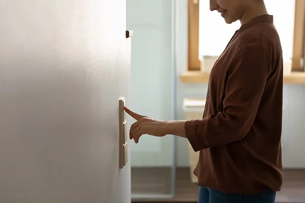 Indian woman switch lights in modern home