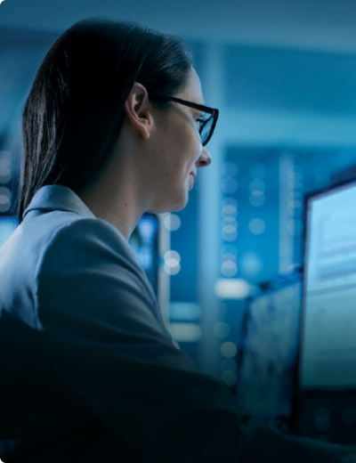 Professional woman working at a computer station in a control center.