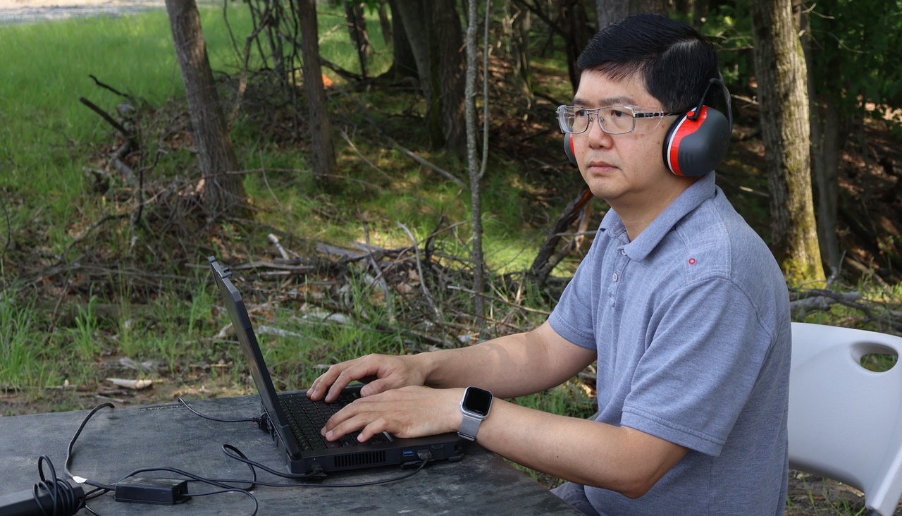 A man with a computer and headphones