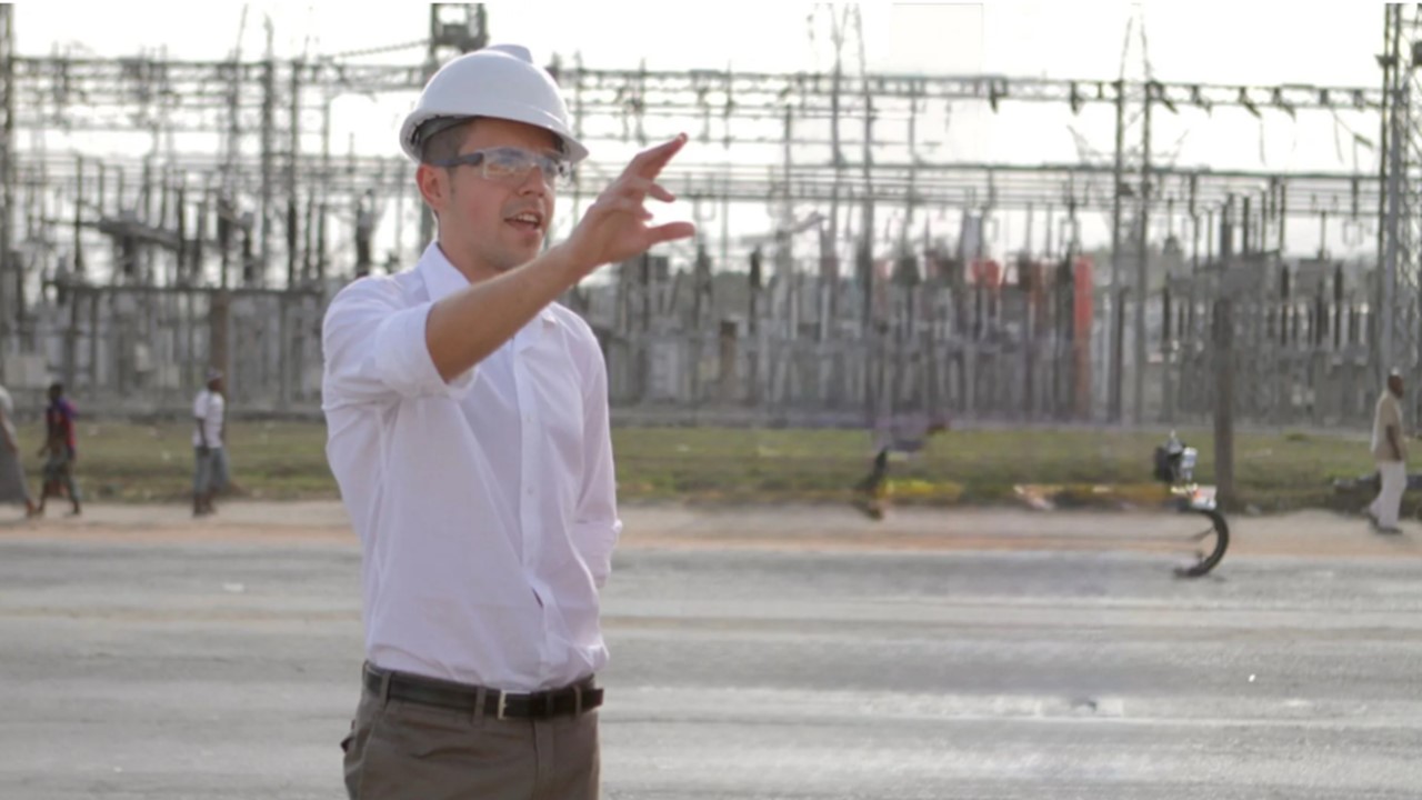 A man with an electrical instalation behind