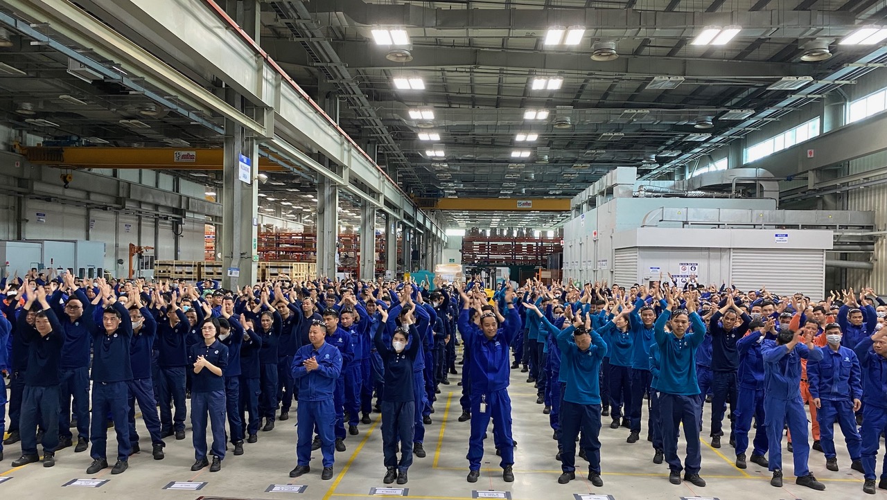 Lines of people in a warehouse all in blue