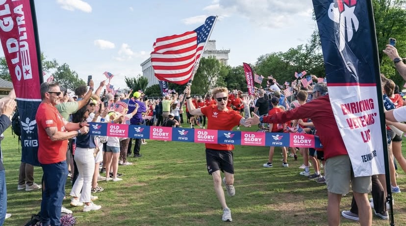 Man carrying American flag across Old Glory finish line