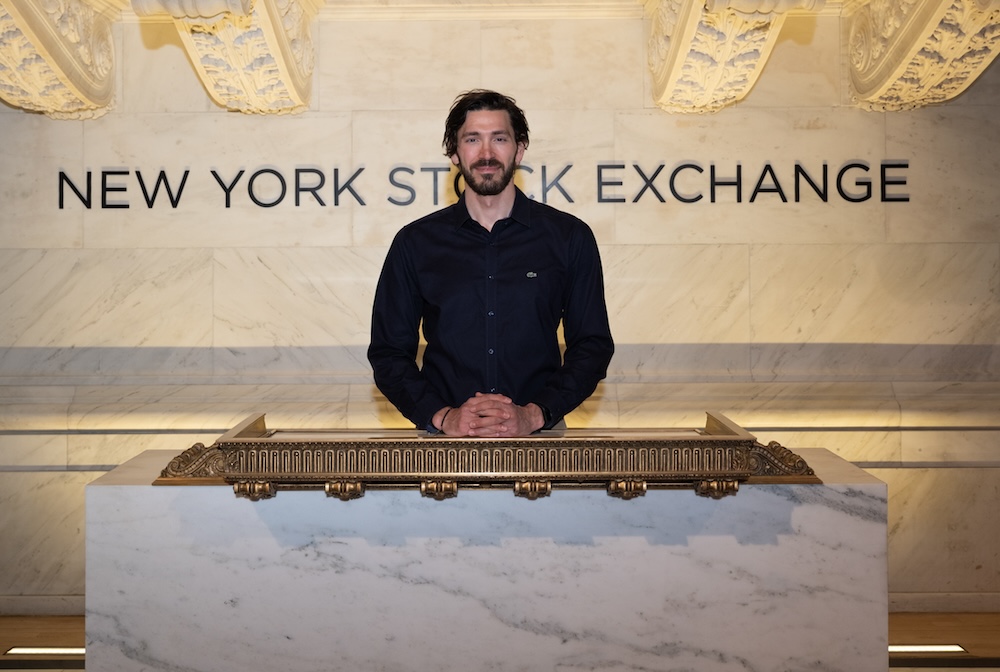 Man standing in front of NYSE sign