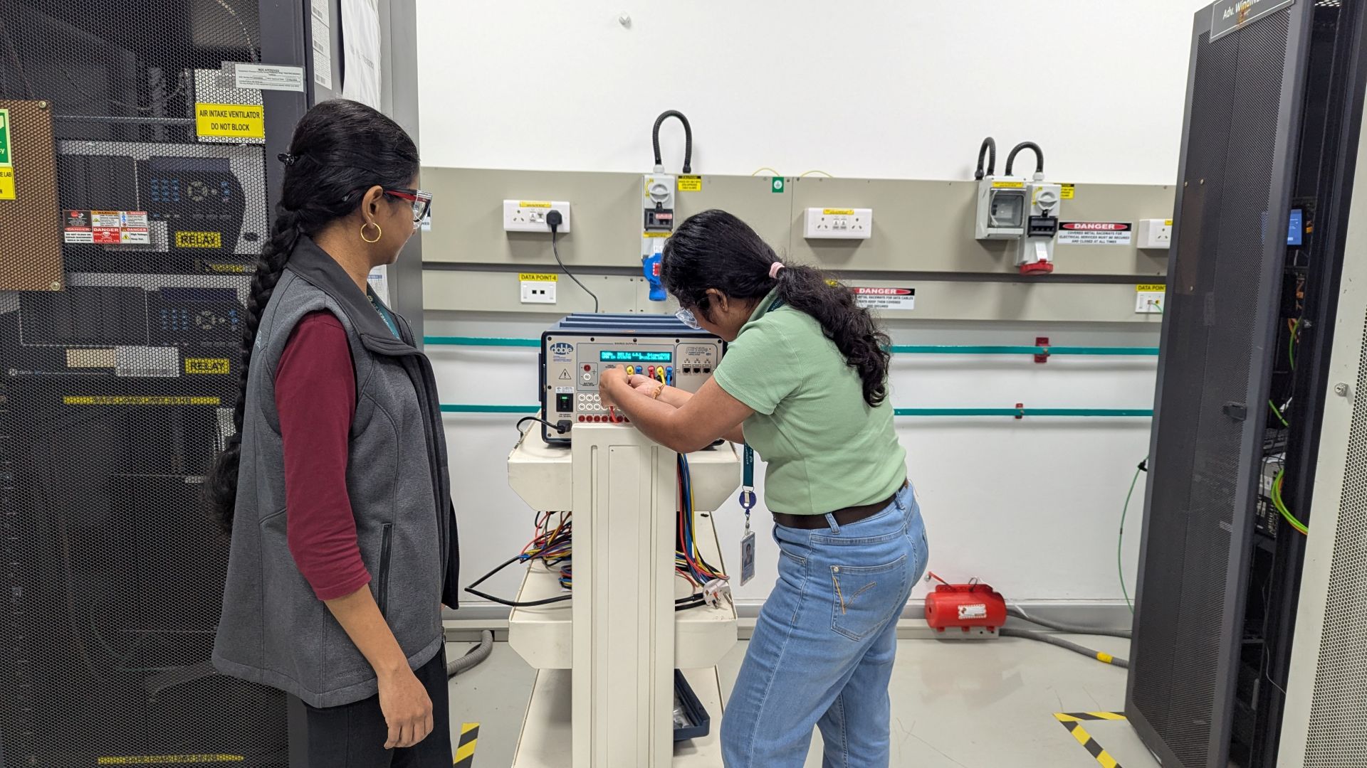 Two women working on a piece of machinery