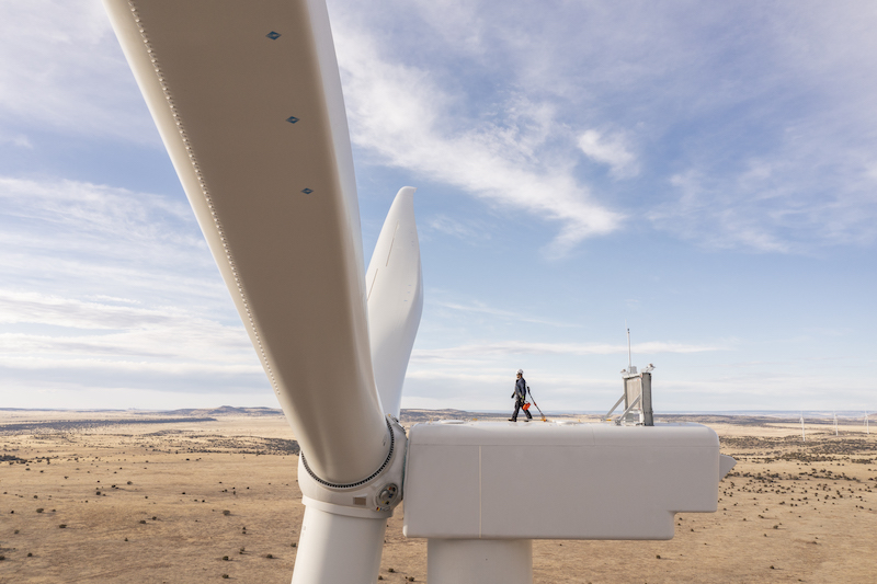 Worker walks across the top of a wind turbine