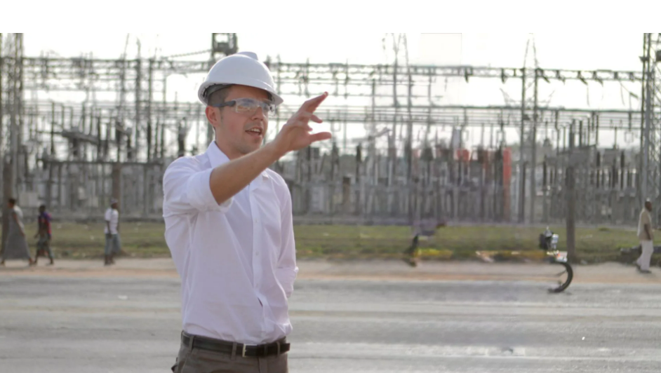 Man in a white button up and hard hat gesturing