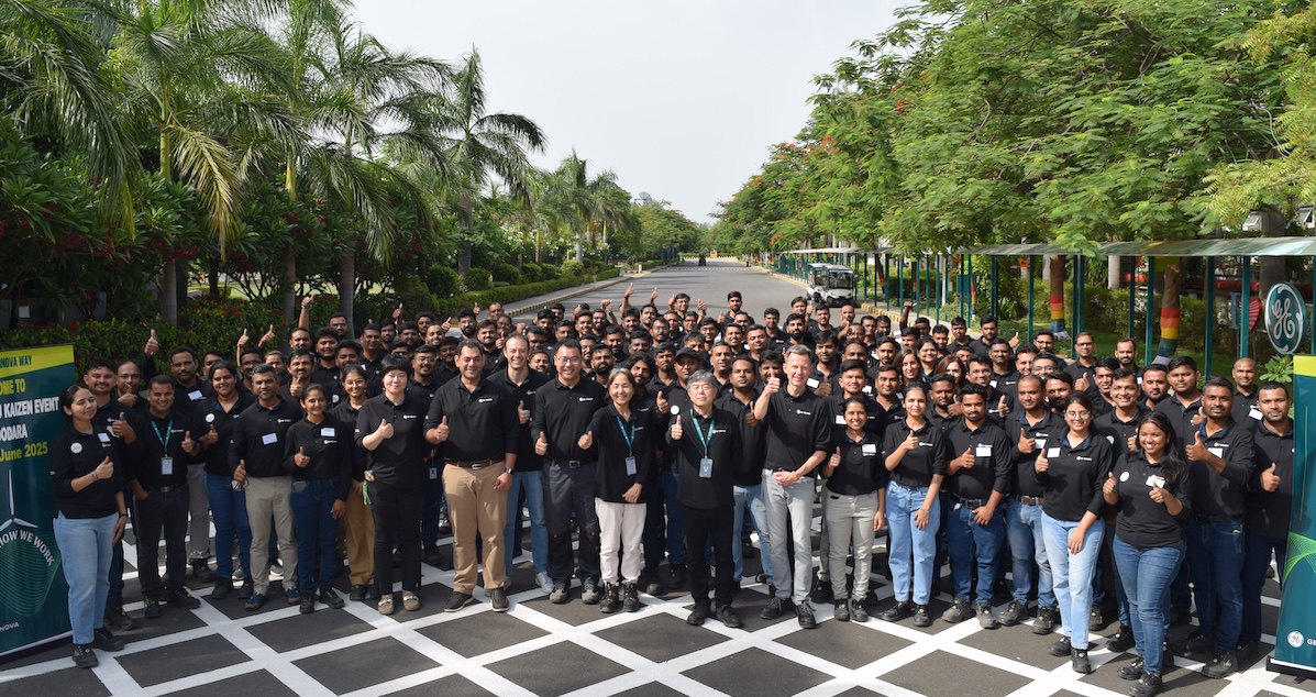 Large group of people standing in a road surrounded by leafy trees